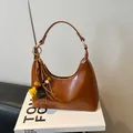 Bruine hobo tas van olie-leer met kwastjes decoratie op stijlvolle modeboeken - Bruin met Hanger