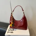 Glanzende donkerrode halve maan hobo tas met gouden details en etnische kwast - Rood met hanger