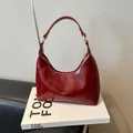 Glanzende bordeauxrode hobo handtas van kunstleer met gouden hardware en bovenhandvat - Rood (Geen Hanger)