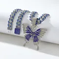 Macro-opname van zilveren cubaanse schakelketting met blauw-witte zirkoon vlinderhanger - Zilver Blauwe Zirkonia Hanger En Cubaanse Ketting
