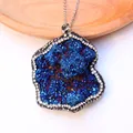 Macro-opname van blauwe druzy steen hanger met witte strassteentjes op houten dienblad - Blauwe glans