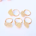 Vista macro de cinco anillos de cristal amarillo en bruto envueltos en hilo chapado - Citrina