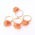 Detalle de cuatro anillos hechos a mano bañados en oro con piedras naturales naranjas - Piedra rosa