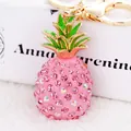 Makroaufnahme: Rosa Ananas-Schlüsselanhänger mit Strass und goldenem Karabinerhaken - Rosa