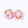 Vue macro de perles en or rose avec fleurs de cerisier en émail rose et strass - Or Rose (Rose)