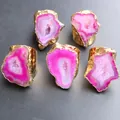Five irregular pink druzy agate rings with gold plated brass bands on black surface - Rose Red