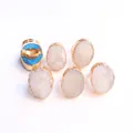 Macro shot of white druzy stone ring with gold electroplated adjustable band and blue base - White