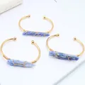 Brazalete abierto dorado con piedra de cristal azul natural y diseño de hilo envuelto - 65mm / Piedra de Arena Azul