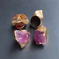 Detail von rohen lila und roten Kristallsteinen auf gehämmerten vergoldeten Ringen - Lila