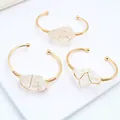 Detailansicht von drei handgefertigten Armreifen mit Golddraht und Bergkristallen - 65mm / Weiß Kristall