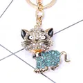 Detail van een glinsterende katten-sleutelhanger met blauwe kristallen en gouden clip - Blauw