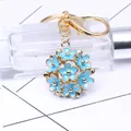 Porte-clés doré avec pendentif boule de fleurs en émail bleu et fermoir mousqueton chic - Bleu