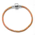 Macro detail of 3mm DIY snake chain bracelet featuring colorful orange and green spray paint - Yellow