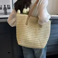Détail du sac cabas en paille tissé à la main avec bandoulières en cuir marron et coutures - Beige