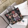 Borsa tote in tela stile etnico con ricamo a gufo colorato e manici a righe sul divano - Gufo Nero