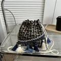 Detail of tweed bucket bag featuring contrast weave texture and fringe tassel accents - Black And Coffee Tweed Style / Black