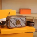 Borsa fotografica vintage con motivo monogramma marrone e tracolla larga su scatola arancione - M Cachi