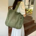 Grass green woven crescent tote bag with wooden bead tassel shown in a lifestyle setting - Single Item / Army Green