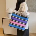 Grande borsa tote in tela a righe colorate con manici in corda indossata a spalla - Colorato