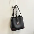 Borsa a secchiello in pelle nera con finiture marroni e ciondolo a lettera D argento - Nero