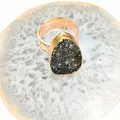 Detalle de racimo de cristal natural en forma de gota en un anillo ajustable dorado - Negro