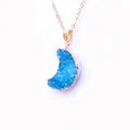 Macro shot of blue druzy moon pendant with gold-plated edges and fine golden chain - Lake Blue
