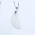 Détail du pendentif aile d'ange en agate blanche avec gravures de plumes et chaîne argentée - Cristal blanc