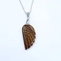 Macro detail of tiger eye stone angel wing pendant with silver necklace on white background - Tiger Eye Stone Bracelet