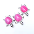 Detail of three silver turtle pendants with pink agate shells and crystal accents - Rose Red
