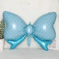 Macro shot of a light blue bow foil balloon with white polka dots on a plush white rug - Candy Bow Tie (Blue)