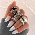 Vintage silver ring set featuring black flame heart, bee, and snake motifs on hand - Antique Silver Bee Snake Heart Collection (54167)