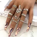 10-piece silver metal ring set featuring snake and star designs worn on model hand - Snake Star Vintage Carved Collection (5357925)