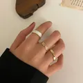 Three-piece gold-tone ring set featuring white enamel finish and elegant chain design - Enamel Mobius Gold Twist Set (52018)