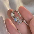 Lava style open silver ring with three iridescent moonstones on a hand model - Three-Stone Moonstone Retro Style - Silver