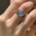 Lava style silver ring with moonstone gemstone inlay on model finger hand - Liquid Metal Blue Stone Style - Silver