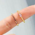 Golden stackable ring set with purple crystals and star motif on a female finger - Gold Purple Crystal Set (5690205)