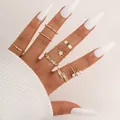 Set di 8 anelli dorati con farfalla, cuore, perle e ciondoli a stella sulla mano - Stile Intrecciato Otto Pezzi Oro (5783501)