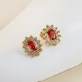 Macro detail of 18K gold-plated earring with red oval gemstone and cubic zirconia - Red Flower Oval Style (E0009) / Gold