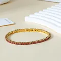 Detailed macro view of 3mm red zircon tennis bracelet with gold-plated stainless steel clasp - Gold (Red Zircon)