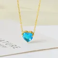 Macro detail of a bright blue heart-shaped gemstone pendant on a golden chain. - 18K Gold (Blue Cubic Zirconia) (N0124G-2)