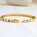 Detailed macro view of gold-plated tennis bracelet with oval cubic zirconia and fold-over clasp - Gold / 18cm