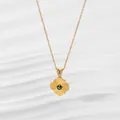Macro view of gold flower pendant with green gem and zircon-set bail on a fine chain - Diamond Gold