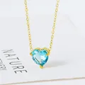 Macro-opname van een gouden hartketting met gefacetteerde blauwe zirkoon hanger op wit - 18K Goud (Lichtblauwe Zirkonia) (N0124G-6)