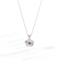 Macro view of silver flower pendant with red gemstone and textured floral petals - Flower Silver