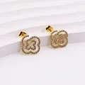 Detail of gold clover earrings with micro-pave white zircons on a wavy display - Clover Swirl Style (E0205G)