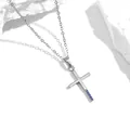 Detailaufnahme einer silbernen Kreuzkette mit blauen Zirkonia auf weißem Marmor - Silber Mit Blauem Zirkonia