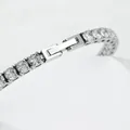 Gros plan détaillé d'un bracelet tennis argenté avec un fermoir à boucle déployante - Argent Largeur 4