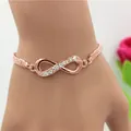 Rose gold infinity bracelet with rhinestones and woven mesh band on a female wrist - Rose Gold Mesh Rhinestone Infinity Bracelet (5780303HB)