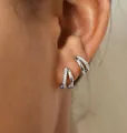 Makroaufnahme von Doppelreifen-Ohrringen aus poliertem Silber mit Pavé-Zirkonia-Steinen - Zweilagiger Strass-Creolen-Stil (5934302HB) / Silber