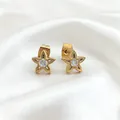 Detailed close-up of golden petal earrings with zircon inlay on a white silk background - Gold